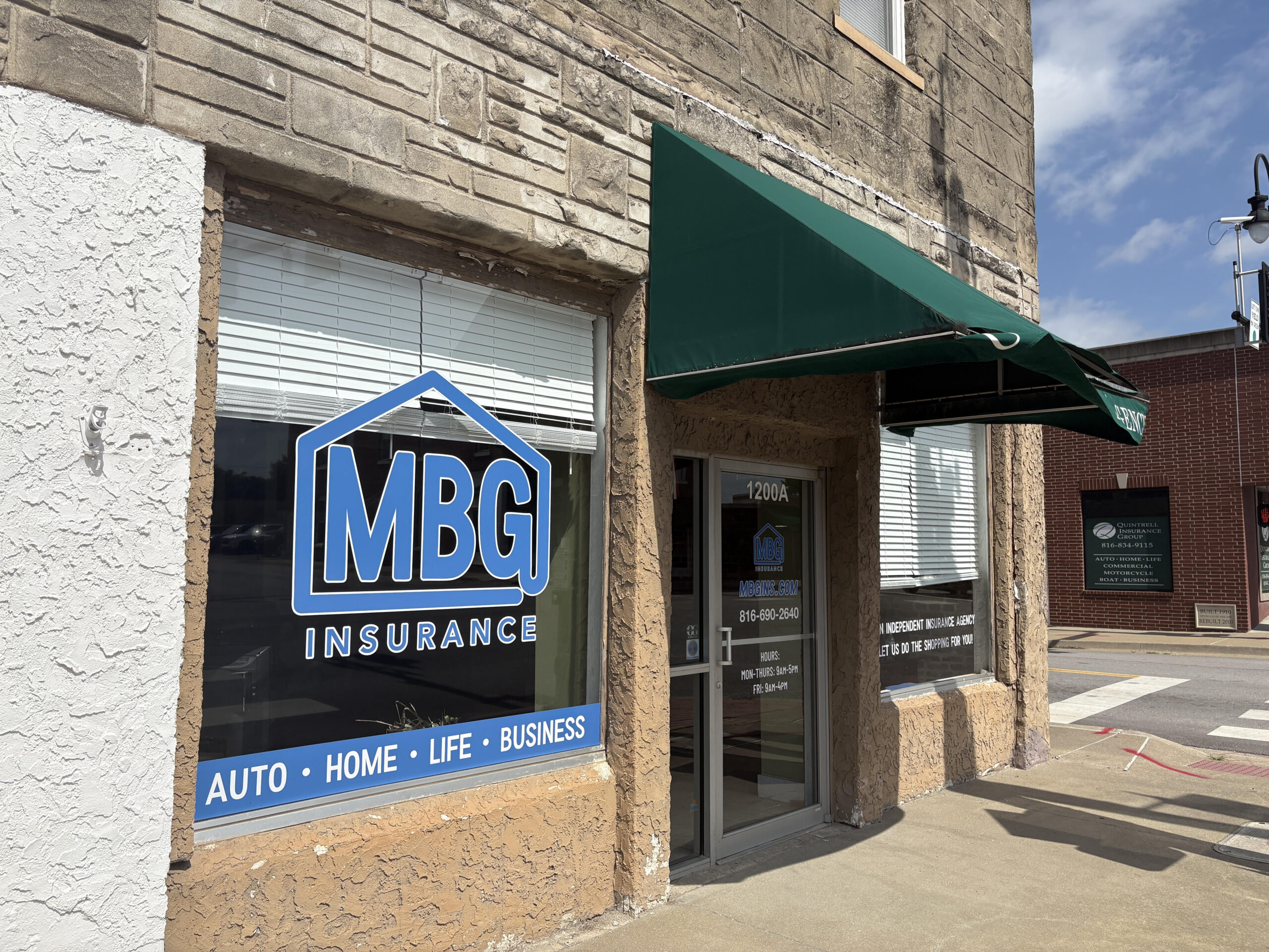 MBG Insurance’s Oak Grove, Missouri office exterior with a green awning and window signage for auto, home, life, and business insurance.