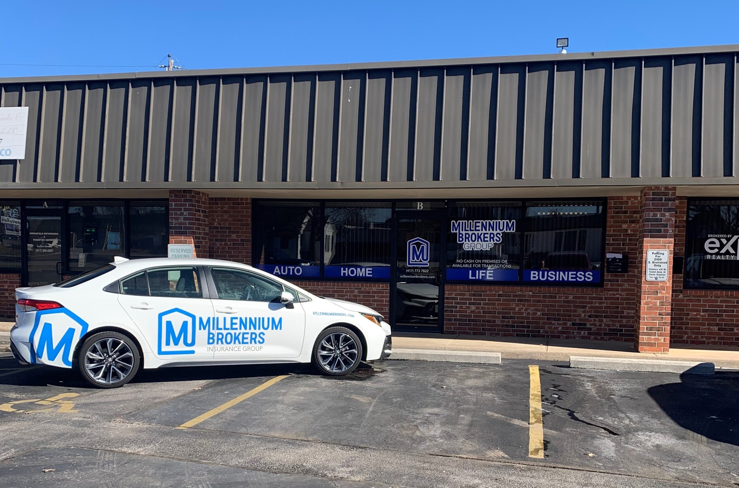 MBG Insurance office exterior with Millennium Brokers storefront signage and a branded company car parked out front.